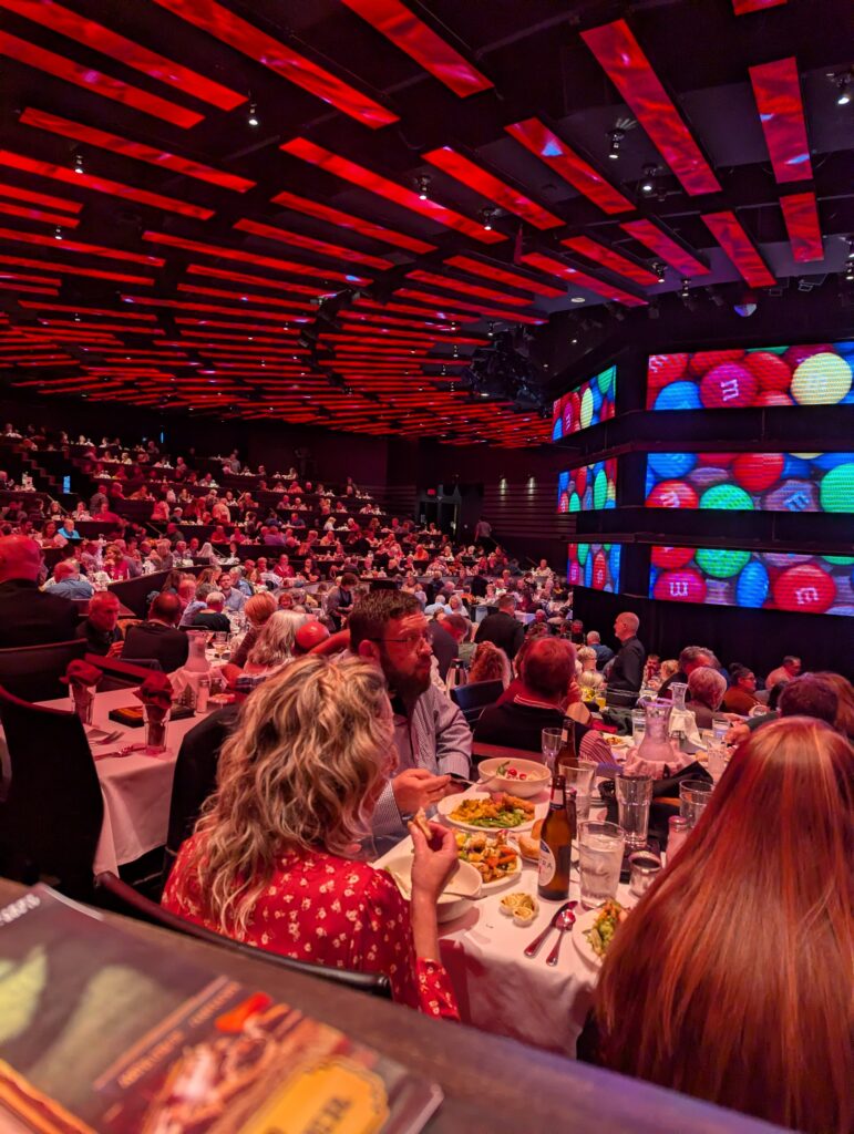 View of the stage at The New Theatre & Restaurant in Overland Park, set for the evening’s performance, with elegant lighting and cozy table seating for dining guests.