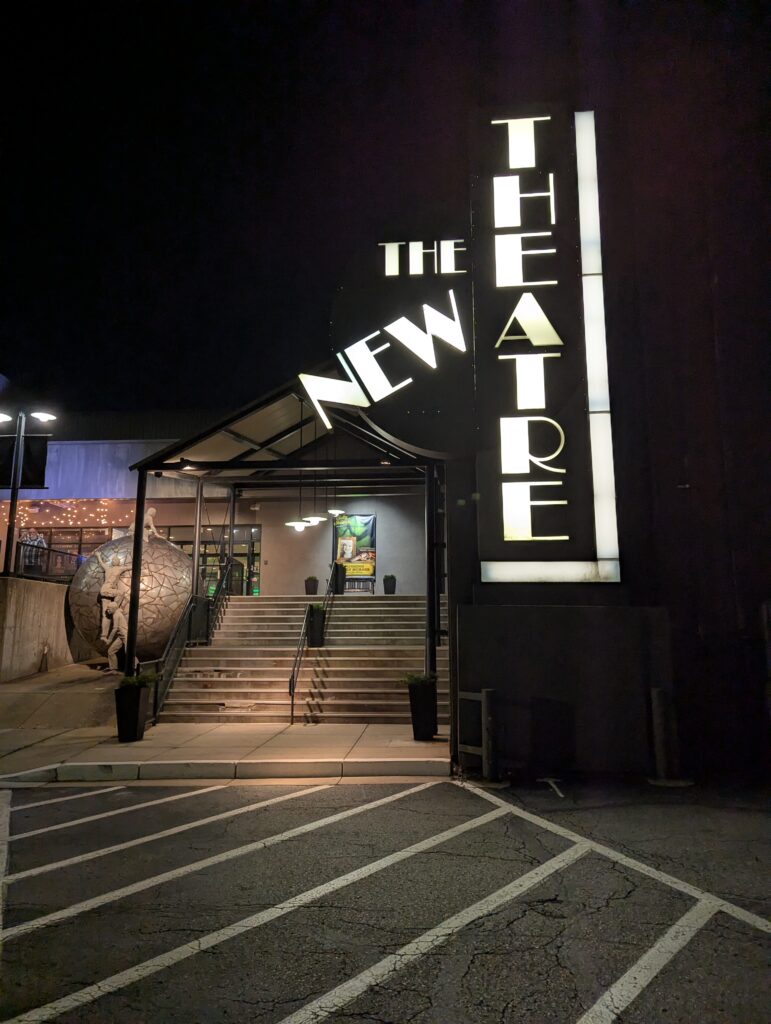 Exterior sign for The New Theatre & Restaurant in Overland Park, Kansas, welcoming guests for an evening of dining and live theater.