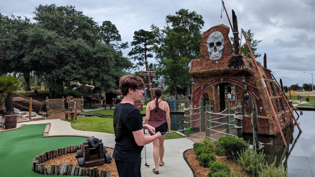 A pirate-themed mini golf course at Pirate’s Island Adventure Golf in Gulf Shores, Alabama, featuring waterfalls and a wooden bridge.