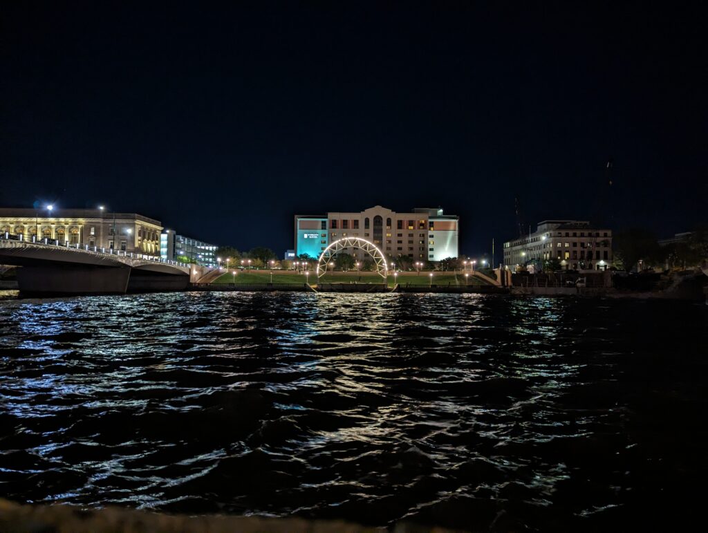 Stunning night view of the Des Moines River with illuminated bridges and cityscape, a serene experience during a weekend in Des Moines.