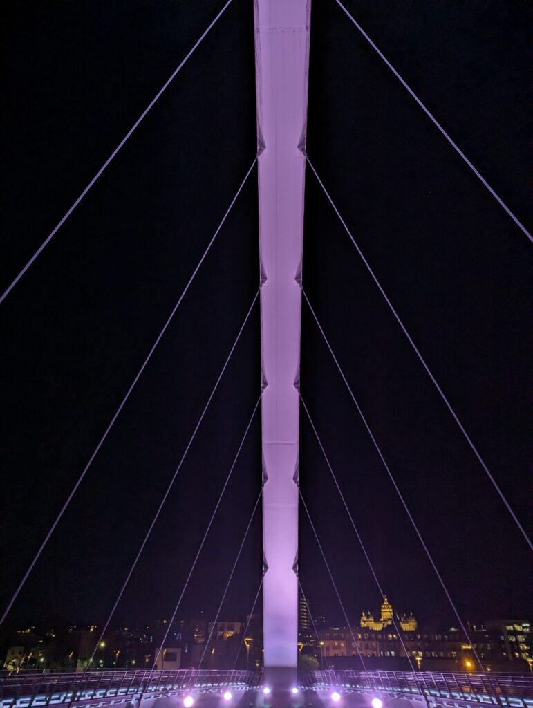 Illuminated Iowa Women of Achievement Bridge spanning the Des Moines River at night, a breathtaking sight during a weekend in Des Moines.